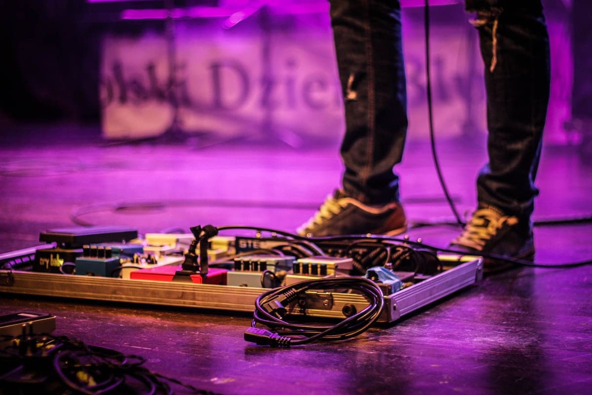 A delay pedal with illuminated LED on a pedalboard