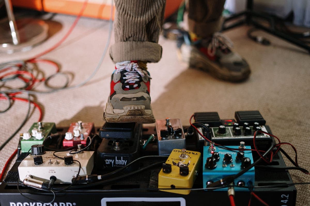 Three gain pedals arranged in a row on a workbench