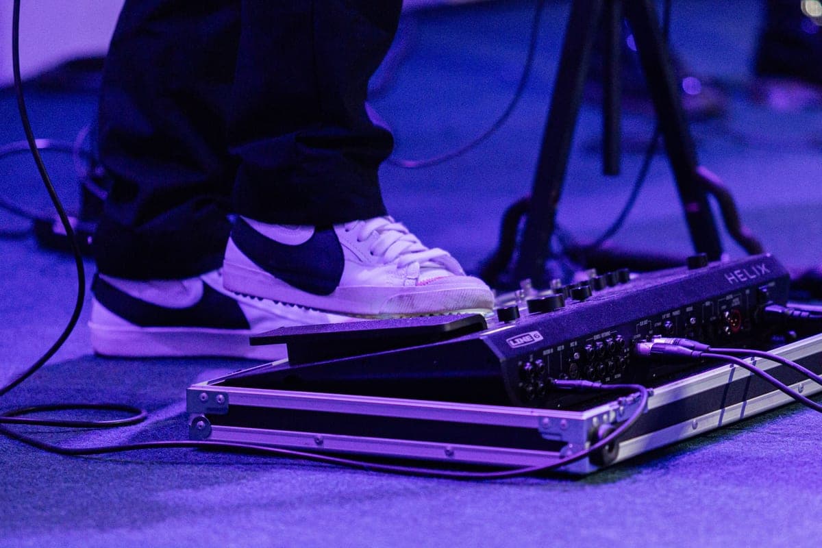 A pedalboard on the floor in front of a combo amplifier