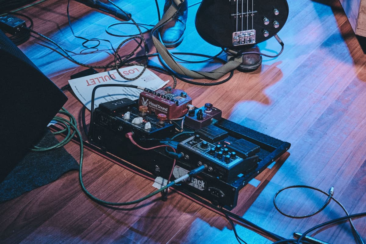 A row of compact guitar effects pedals on a dark surface